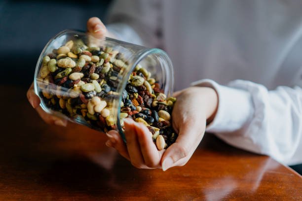 womans hands holding pot with nuts. walnut, pistachios, almonds, hazelnuts